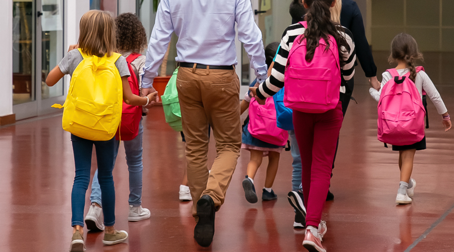 Uns alumnes entrant a l'escola amb els seus pares