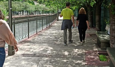 Gent al passeig del riu amb la mascareta a la mà
