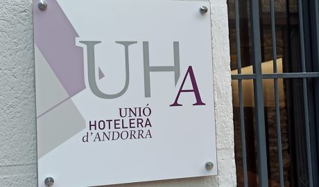 Cartell amb el logotip de la Unió Hotelera d'Andorra a la porta del seu local