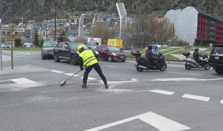 Un operari retirant el producte lliscant de la carretera