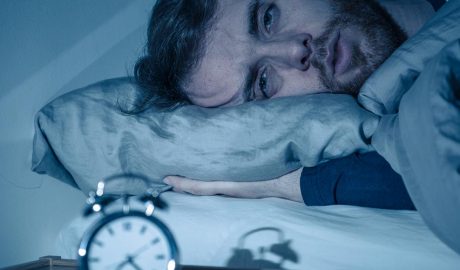 Home amb insomni i un rellotge