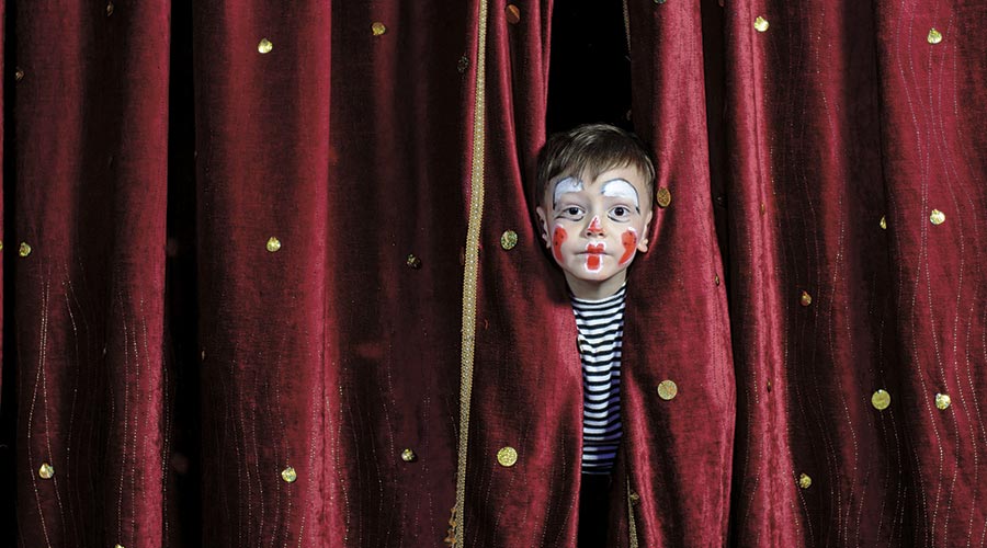 Nen entre telons d'un teatre