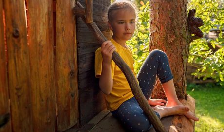 Nena en una caseta en un arbre