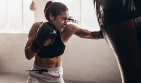 Una dona colpejant un sac de boxa