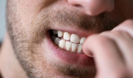 Un home mossegant-se les ungles