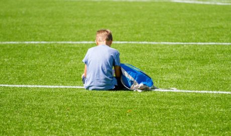 Nen sol en un camp de futbol