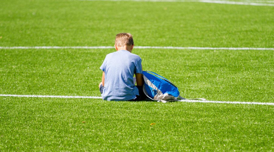 Nen sol en un camp de futbol