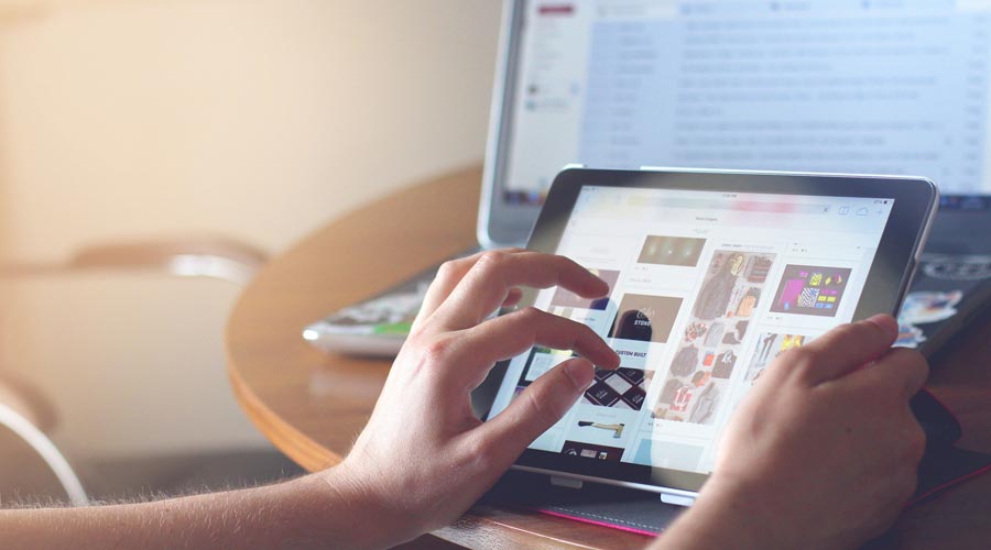 Una dona amb una tauleta i un ordinador