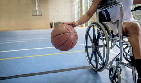 Un noi jugant a bàsquet en cadira de rodes