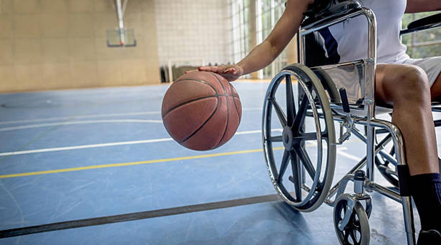 Un noi jugant a bàsquet en cadira de rodes