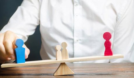 Una balança de fusta on hi ha les figures d'un home i una dona