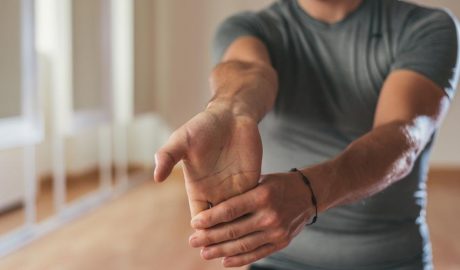 Un home fent estiraments del braç i la mà
