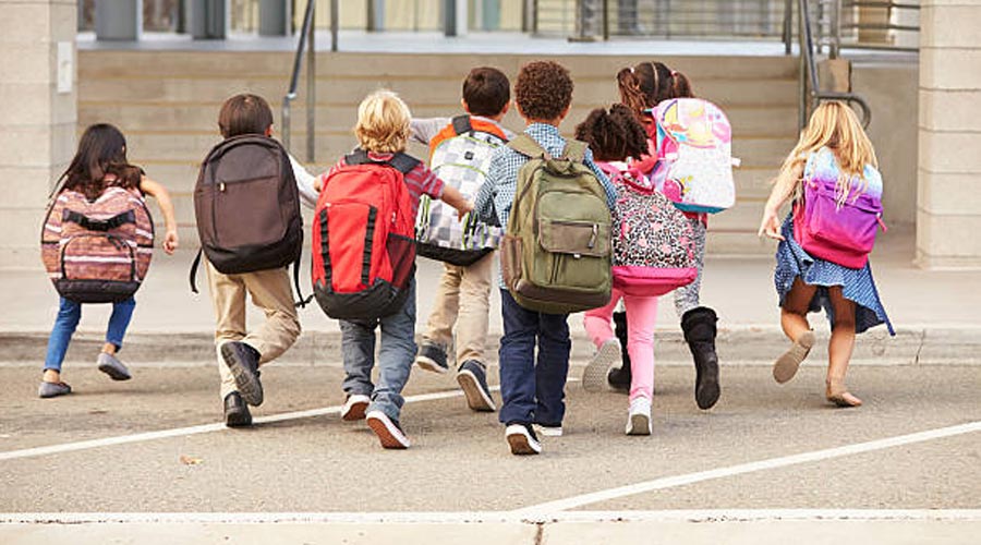 Infants entrant a l'edifici de l'escola