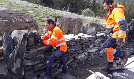 Dos homes construint un marge de pedra seca