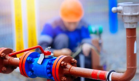 Un lampista arreglant una canalització d'aigua