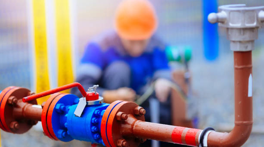 Un lampista arreglant una canalització d'aigua