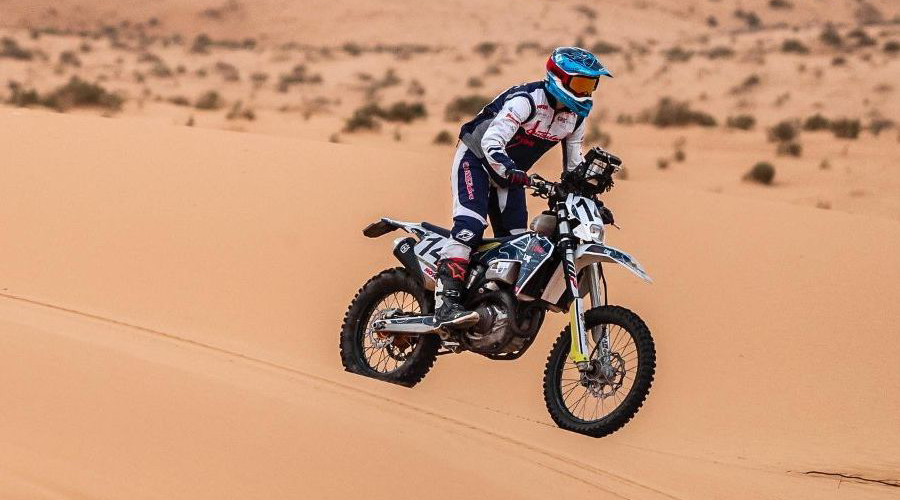 Margot Llobera damunt de la seva moto, en acció, en el desert d'Aràbia Saudita