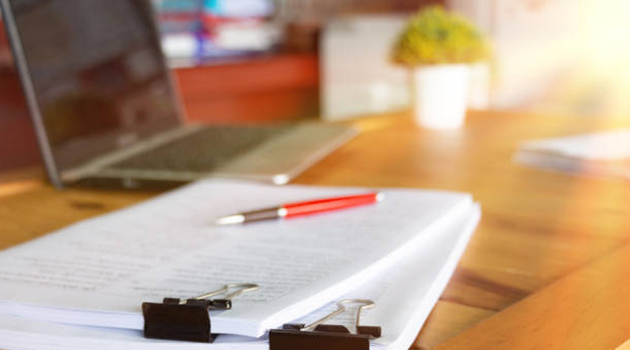 Un ordinador portàtil i uns apunts d'estudiant