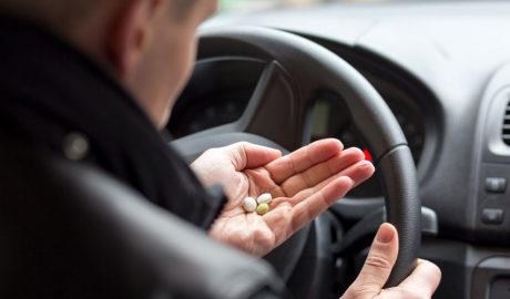 Un conductor prenent medicaments al volant