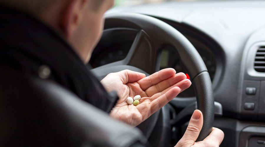 Un conductor prenent medicaments al volant