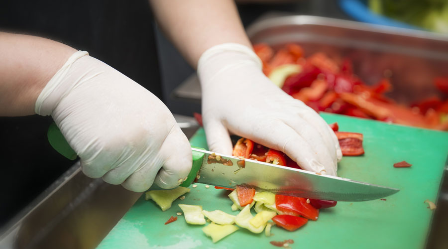 Una persona cuinant amb guants de làtex