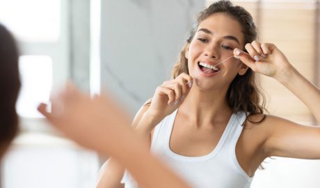 Una dona utilitzant fil dental