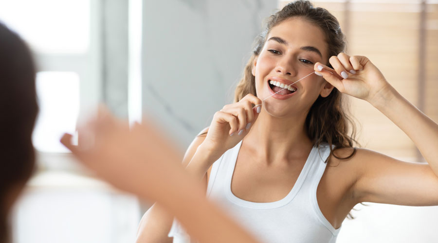 Una dona utilitzant fil dental