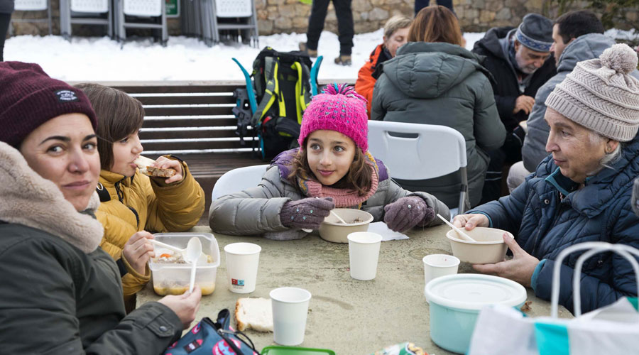 Grans i petits degustant l'escudella a la Massana