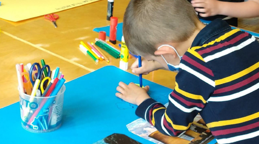 Un infant en una activitat d'Unicef a la biblioteca del Pas