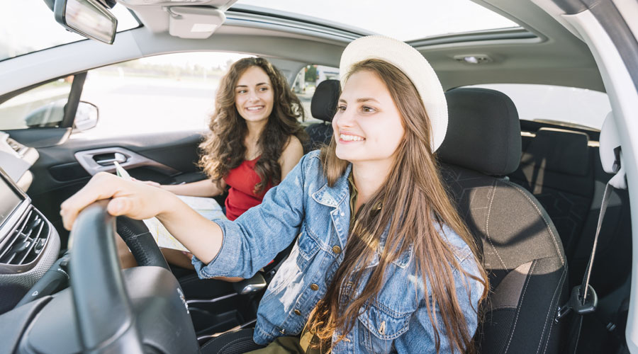 Unes noies compartint cotxe (Freepik)