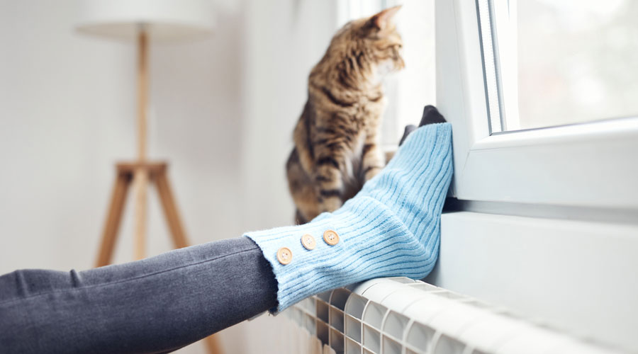 Una dona escalfant-se els peus amb la calefacció (iStock)