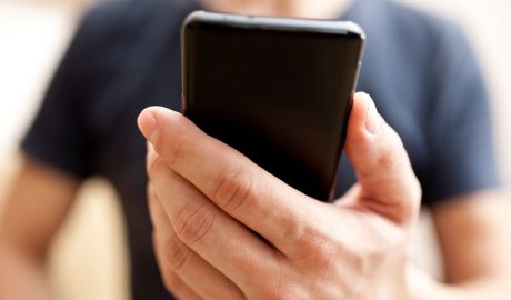 Un home mirant al mòbil l'aplicació d'Snapchat