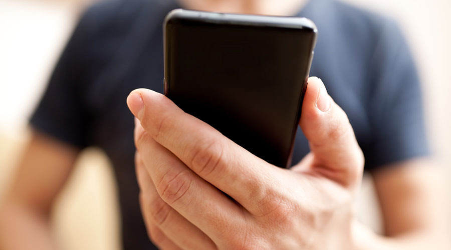 Un home mirant al mòbil l'aplicació d'Snapchat