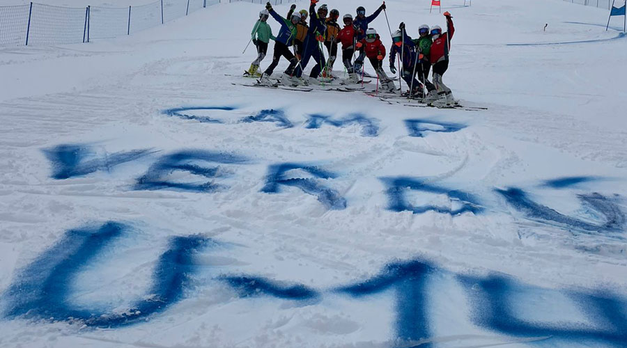 Els joves esquiadors del campus havent pintat el nom de Joan Verdú damunt la neu (FAE)