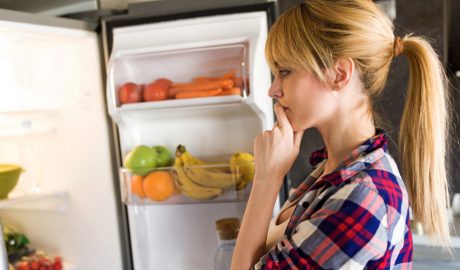 Una noia buscant menjar a la nevera