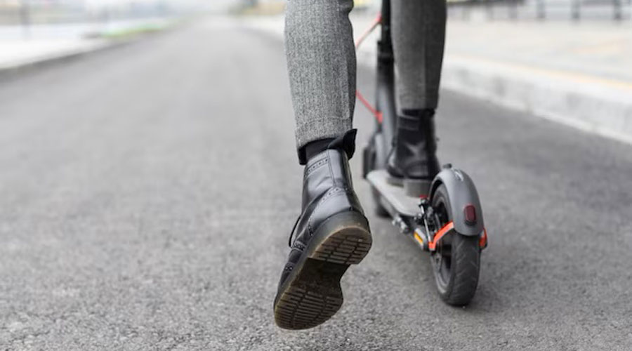 Un home damunt d'un patinet elèctric (freepik)