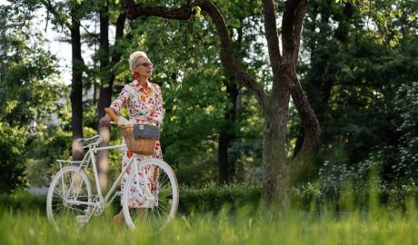Una dona caminant al costat de la seva bicicleta