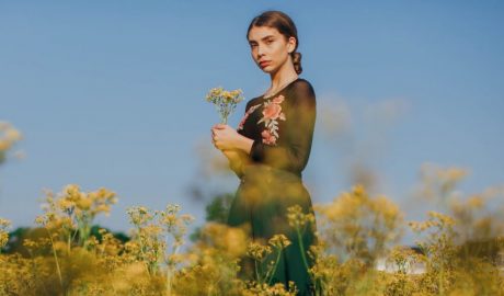 Una dona jove entre flors silvestres al camp