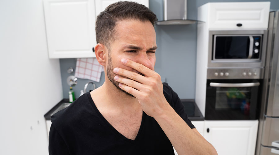 Un home sentint males olors a la cuina (iStock)