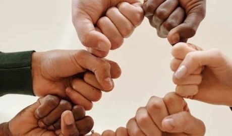 Mans de persones de races diferents simbolitzant la cooperació