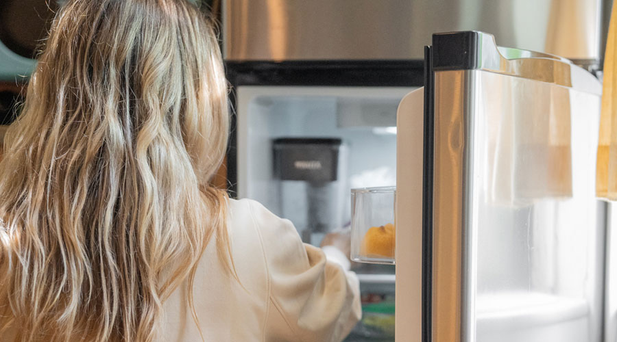Una dona posant cosmètics a la nevera (AMIC)