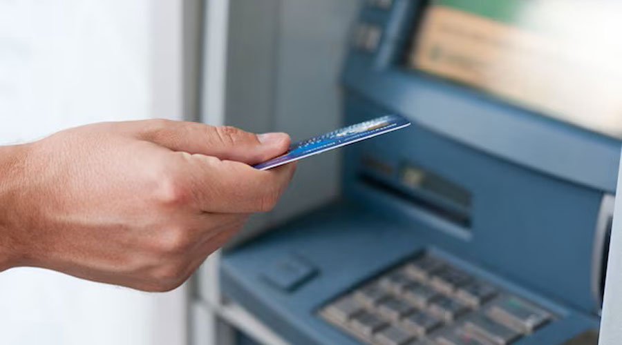 Home utilitzant una tarja de crèdit en un caixer automàtic (Dragana_Gordic / freepik)