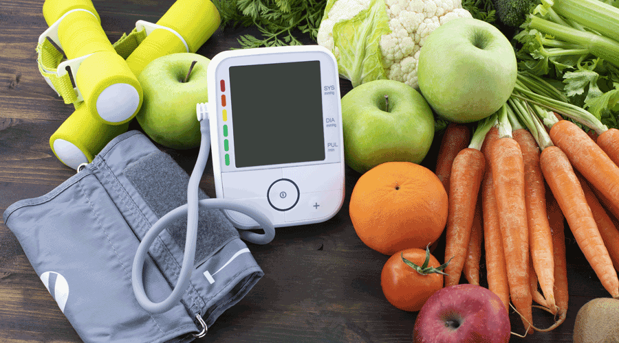 Aparell per a mesurar la tensió envoltat de menjar saludable (Getty images)