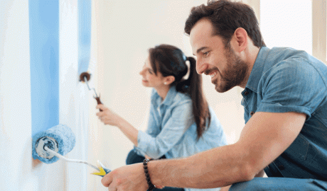 Una parella pintant una habitació de la llar