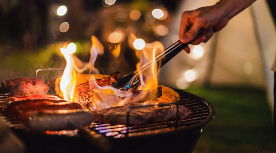 Un home fent una barbacoa amb un excés de flama (iStock)