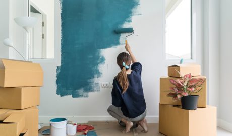 Una dona pintant una paret de la llar