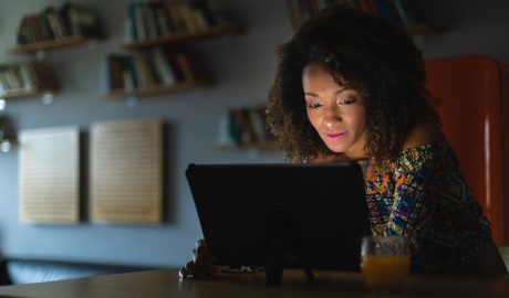 Una dona mirant un dispositiu digital durant la nit