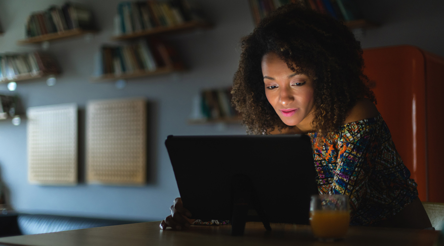 Una dona mirant un dispositiu digital durant la nit (AMIC)