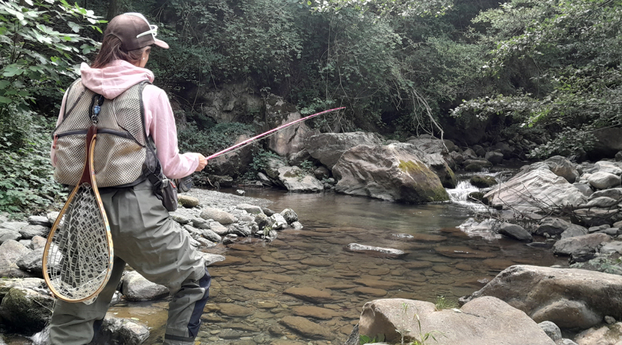 Una dona pescant en un riu de baixa muntanya