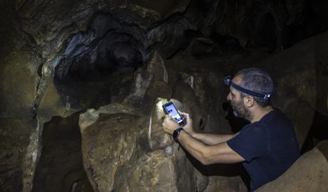 Investigador descarregant dades del sensor de temperatura instal·lat a la cova dels Muricecs de Llimiana